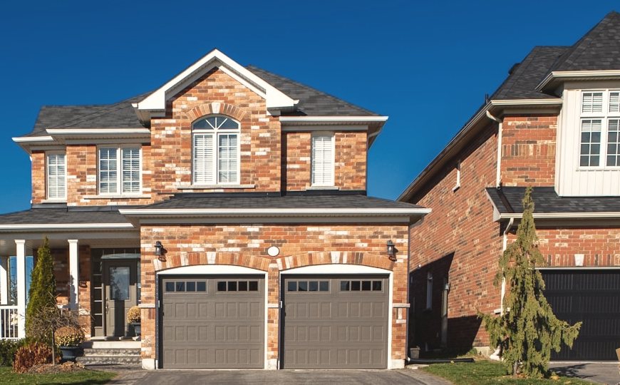 A two-story brick house with a pitched roof and a double garage